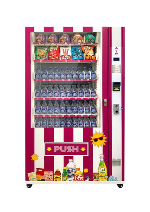 Bright pink vending machine with snacks and beverages on shelves, coin slot, and push button for dispensing items